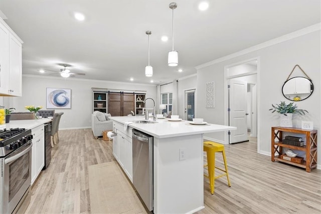 kitchen with stainless steel appliances, a breakfast bar, a sink, white cabinets, and ornamental molding