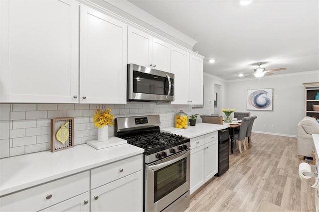 kitchen featuring white cabinetry, light countertops, appliances with stainless steel finishes, tasteful backsplash, and crown molding