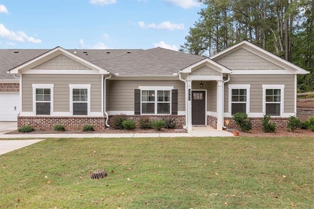 craftsman-style house featuring roof with shingles, brick siding, and a front lawn