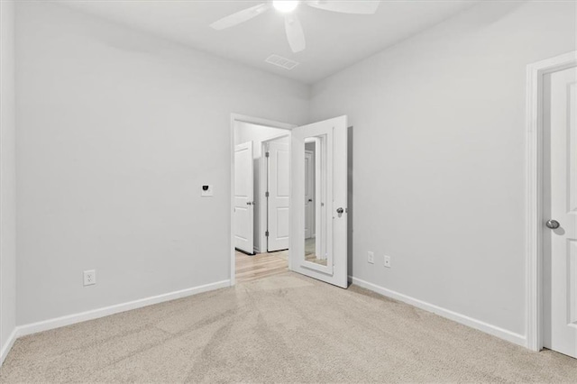 unfurnished bedroom featuring carpet, visible vents, baseboards, and ceiling fan