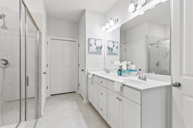 full bath featuring a stall shower, tile patterned floors, a sink, and double vanity