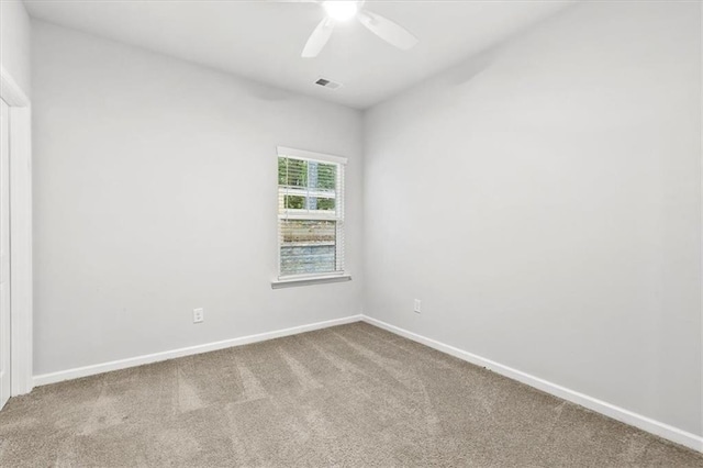 empty room featuring a ceiling fan, baseboards, visible vents, and carpet flooring