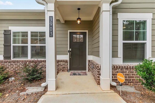 doorway to property featuring brick siding