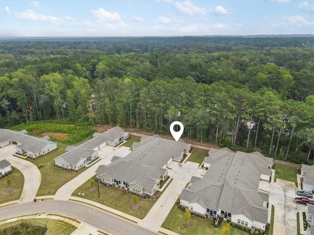 drone / aerial view featuring a wooded view