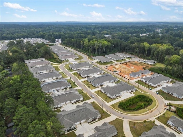 drone / aerial view featuring a residential view and a wooded view