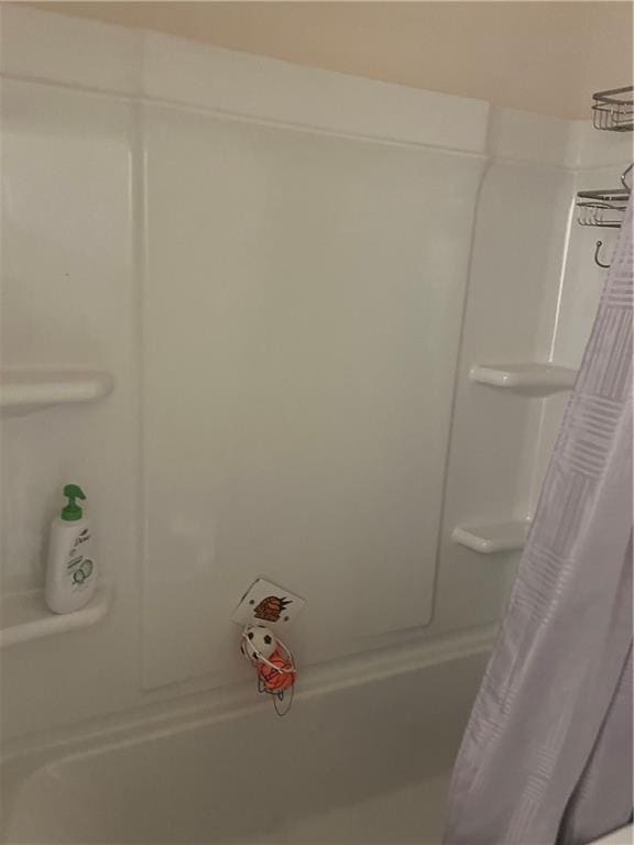 bathroom with shower / bath combo with shower curtain