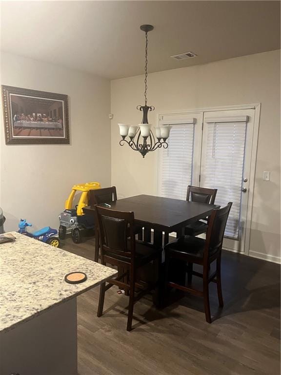 dining area with an inviting chandelier and dark wood-type flooring