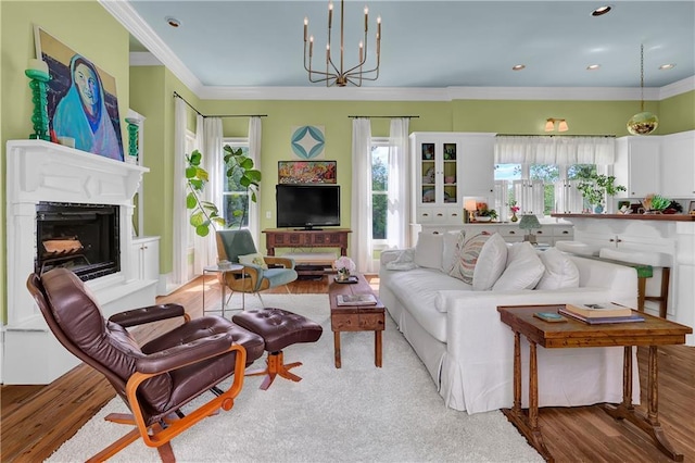 living room featuring ornamental molding, light hardwood / wood-style floors, and a notable chandelier