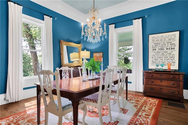 dining area featuring wood-type flooring, plenty of natural light, and a chandelier