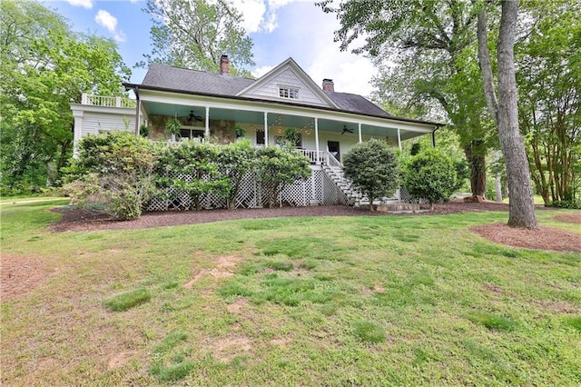 country-style home featuring covered porch, ceiling fan, and a front lawn