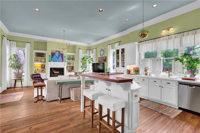 kitchen with pendant lighting, sink, a breakfast bar, dishwasher, and white cabinets