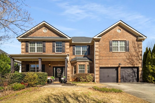 view of front of home with driveway, a garage, and brick siding