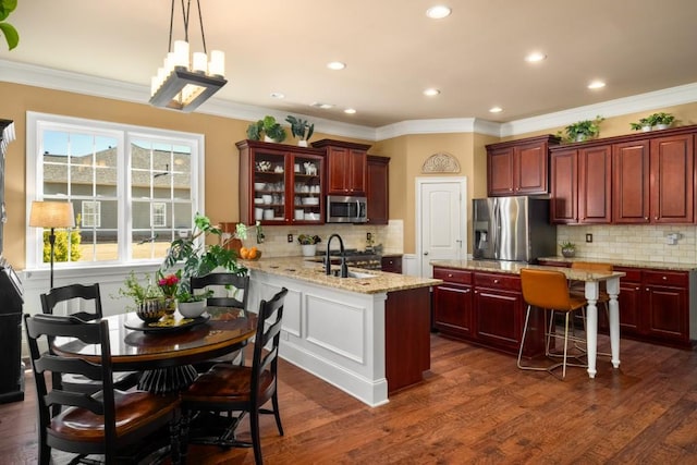 kitchen featuring reddish brown cabinets, appliances with stainless steel finishes, a sink, and dark wood-style floors