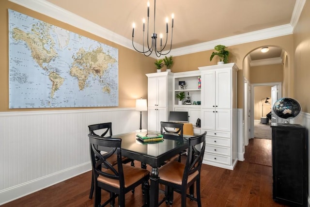 dining room with a wainscoted wall, arched walkways, and dark wood finished floors