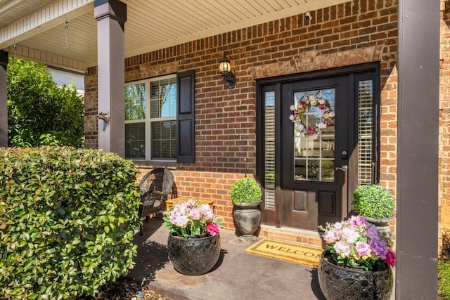 property entrance featuring brick siding and a porch