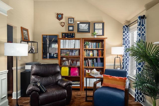 living area featuring baseboards, vaulted ceiling, and wood finished floors