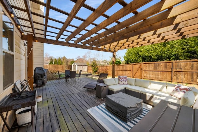 wooden deck featuring an outbuilding, an outdoor hangout area, outdoor dining space, a shed, and a fenced backyard