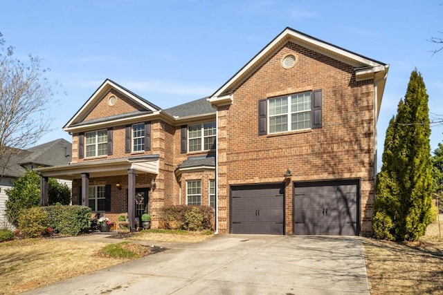 traditional-style house with driveway, an attached garage, and brick siding