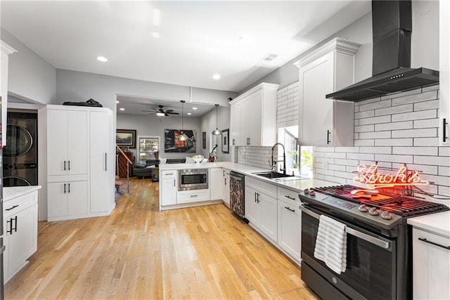 611 Pickett St SE, Atlanta, GA 30316 - kitchen featuring appliances with stainless steel finishes, wall chimney exhaust hood, a sink, estacked washer and dryer, and ceiling fan