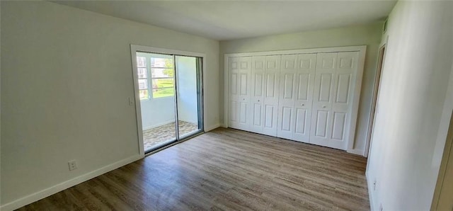 unfurnished bedroom with hardwood / wood-style flooring and a closet