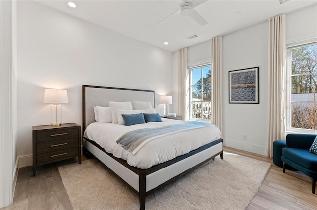 bedroom with multiple windows, ceiling fan, and light hardwood / wood-style flooring