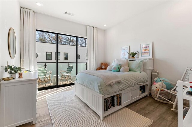 bedroom featuring wood-type flooring and access to outside