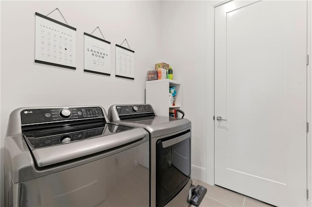 washroom featuring washing machine and clothes dryer and light tile patterned flooring