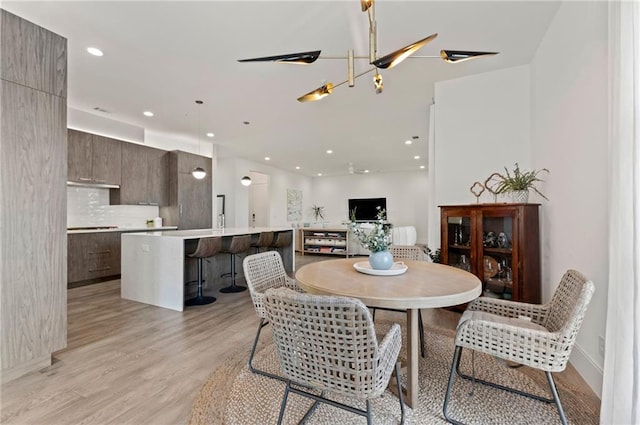 dining space with an inviting chandelier and light wood-type flooring