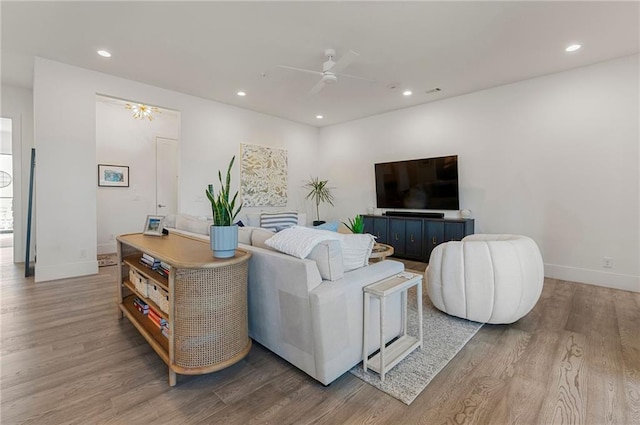 living room featuring wood-type flooring and ceiling fan