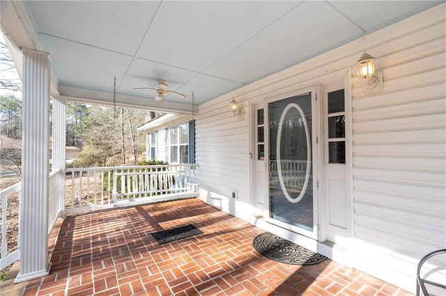 view of exterior entry featuring ceiling fan and covered porch