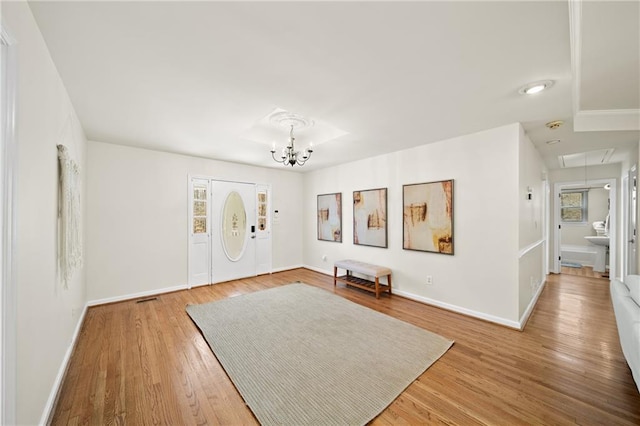 entryway featuring an inviting chandelier and wood-type flooring