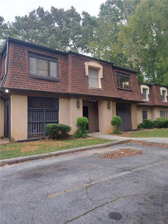 2968 Parc Lorraine, Lithonia, GA 30038 - view of front of property featuring mansard roof, roof with shingles, and stucco siding