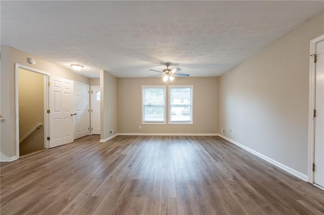 empty room featuring ceiling fan, hardwood / wood-style floors, and a textured ceiling