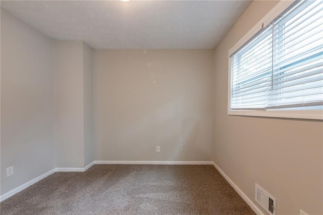 carpeted spare room featuring a textured ceiling