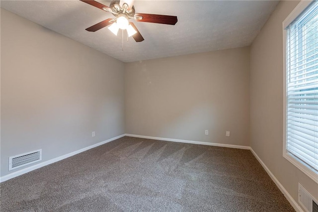 empty room with ceiling fan and carpet flooring