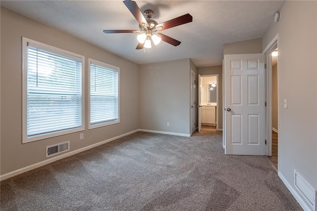 unfurnished bedroom with ensuite bath, ceiling fan, and light colored carpet