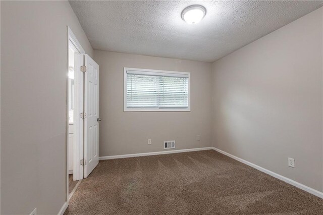 unfurnished bedroom with a textured ceiling and carpet