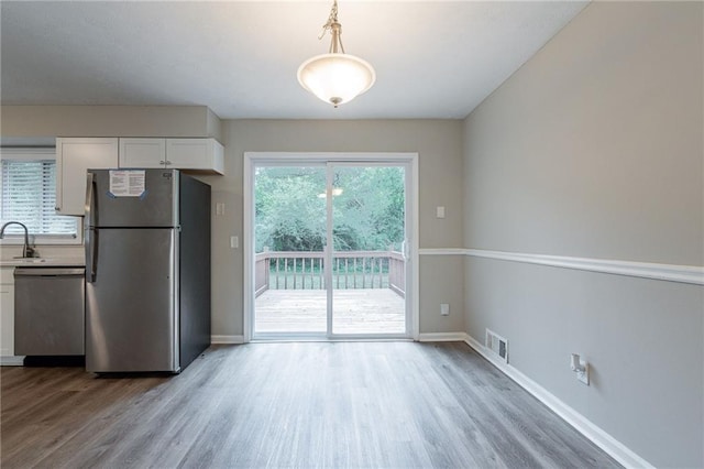 kitchen featuring stainless steel appliances, light wood-type flooring, and white cabinetry