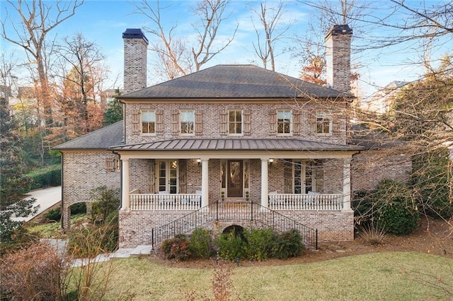 back of property featuring a porch and a yard