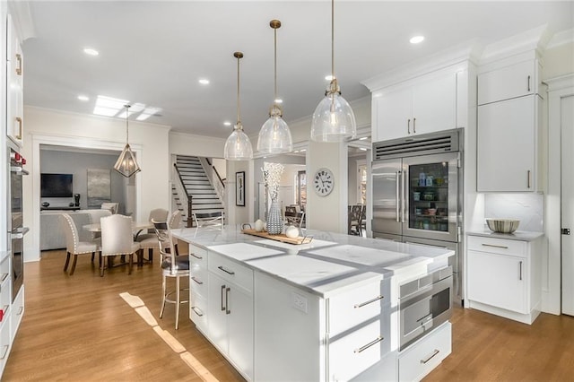 kitchen featuring a center island, white cabinetry, and hanging light fixtures