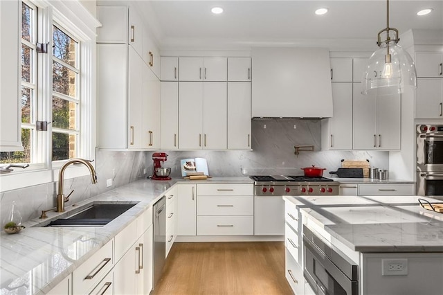 kitchen featuring tasteful backsplash, stainless steel appliances, sink, white cabinetry, and hanging light fixtures