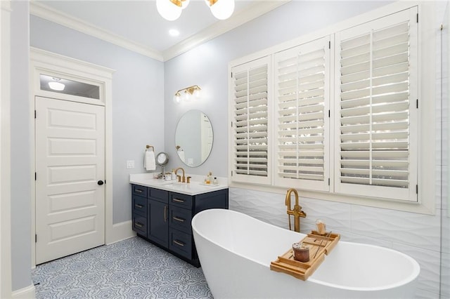 bathroom with a bathtub, vanity, tile patterned floors, crown molding, and tile walls