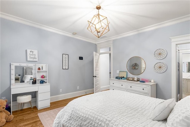 bedroom featuring a notable chandelier, ornamental molding, connected bathroom, and light hardwood / wood-style flooring