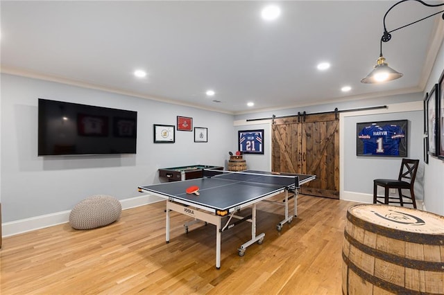 playroom with a barn door, light wood-type flooring, crown molding, and billiards