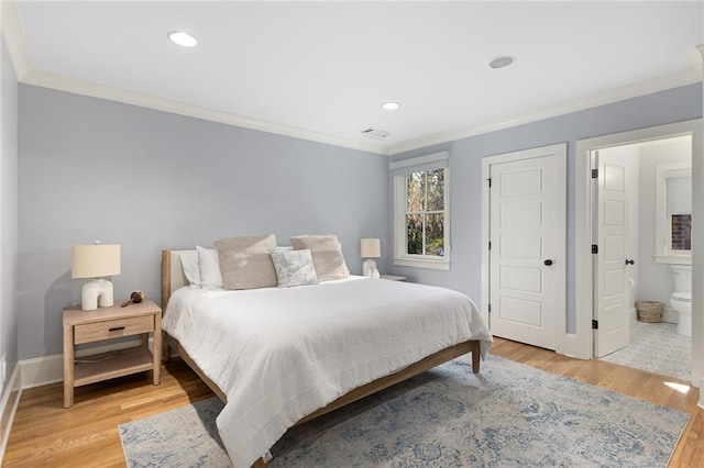 bedroom featuring ensuite bath, ornamental molding, and light wood-type flooring