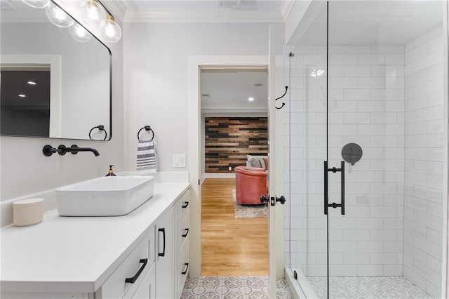 bathroom with tile patterned floors, ornamental molding, a tile shower, vanity, and wooden walls