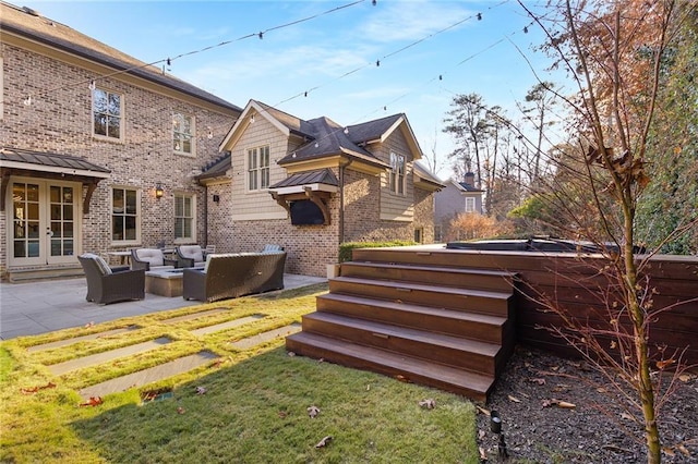 exterior space featuring a lawn, outdoor lounge area, french doors, a hot tub, and a patio area