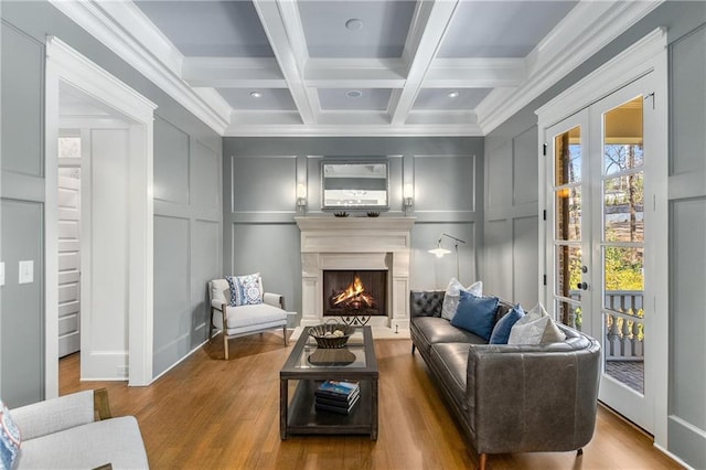 sitting room featuring beam ceiling, ornamental molding, coffered ceiling, and wood-type flooring