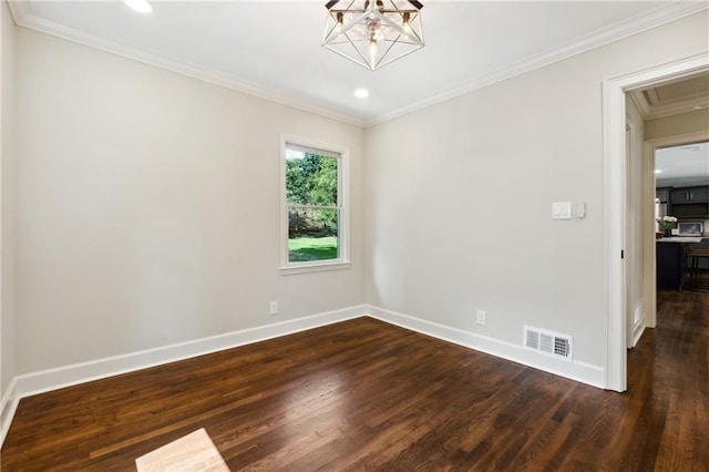 spare room featuring dark hardwood / wood-style flooring, ornamental molding, and a notable chandelier