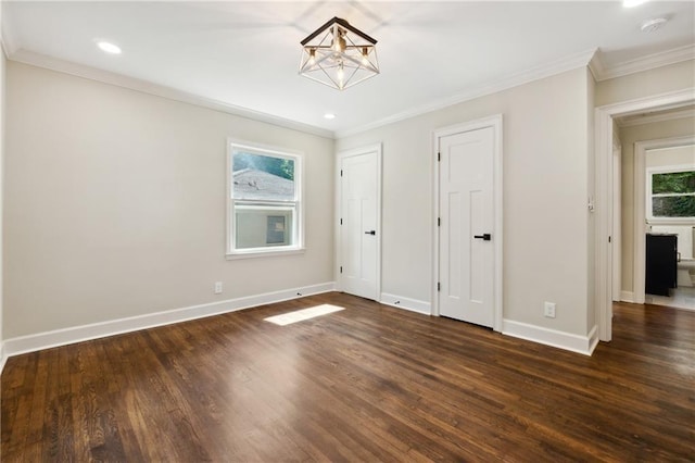 unfurnished bedroom featuring multiple windows, crown molding, and dark hardwood / wood-style flooring